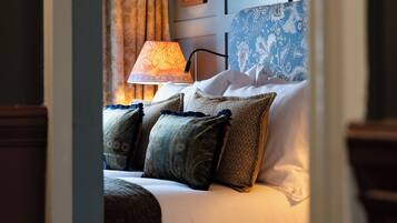 Ein Hotelzimmer mit einem Bett, einer Lampe und einer Wand mit gerahmten Kunstwerken.