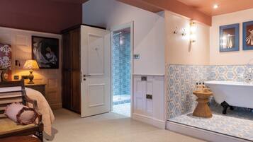 A bathroom with a bathtub, a shower, and a sink. There is a door leading to another room.
