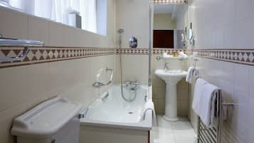 A bathroom with a bathtub, sink, and shower.