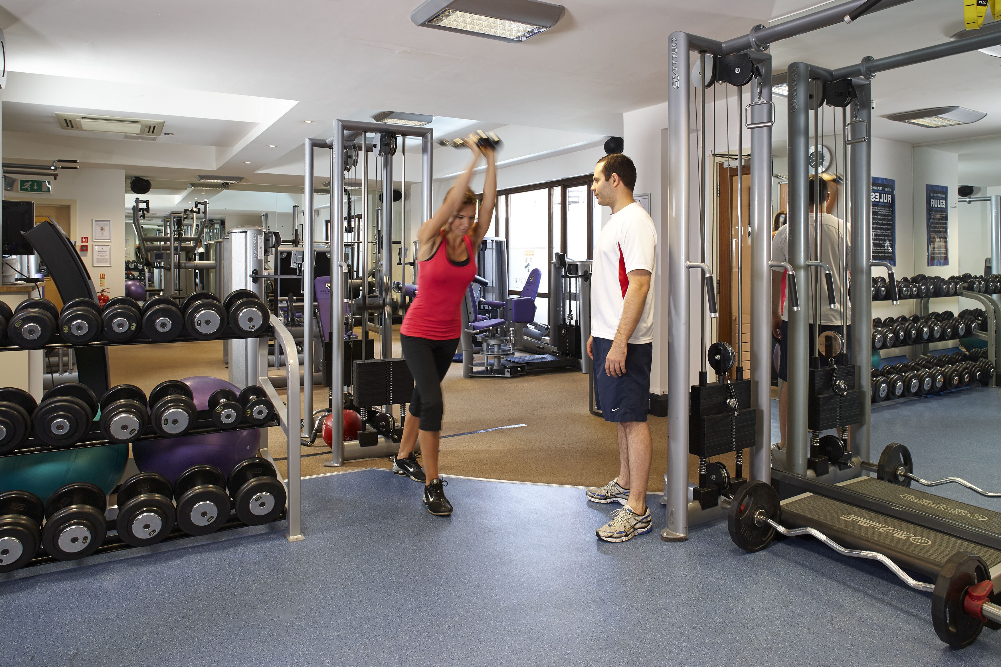 A gym with exercise equipment, a weight rack, and a mirror.