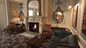 A room with a fireplace, a sofa, armchairs, and a patterned carpet. - Sir Christopher Wren Hotel (Windsor)
