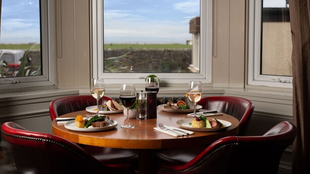 A dining table with plates of food, glasses of wine, and a candle. - Fairfield House - Ayr (Ayr)