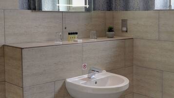 Un bagno moderno con lavabo integrato, uno specchio sopra e un asciugamano sul ripiano.