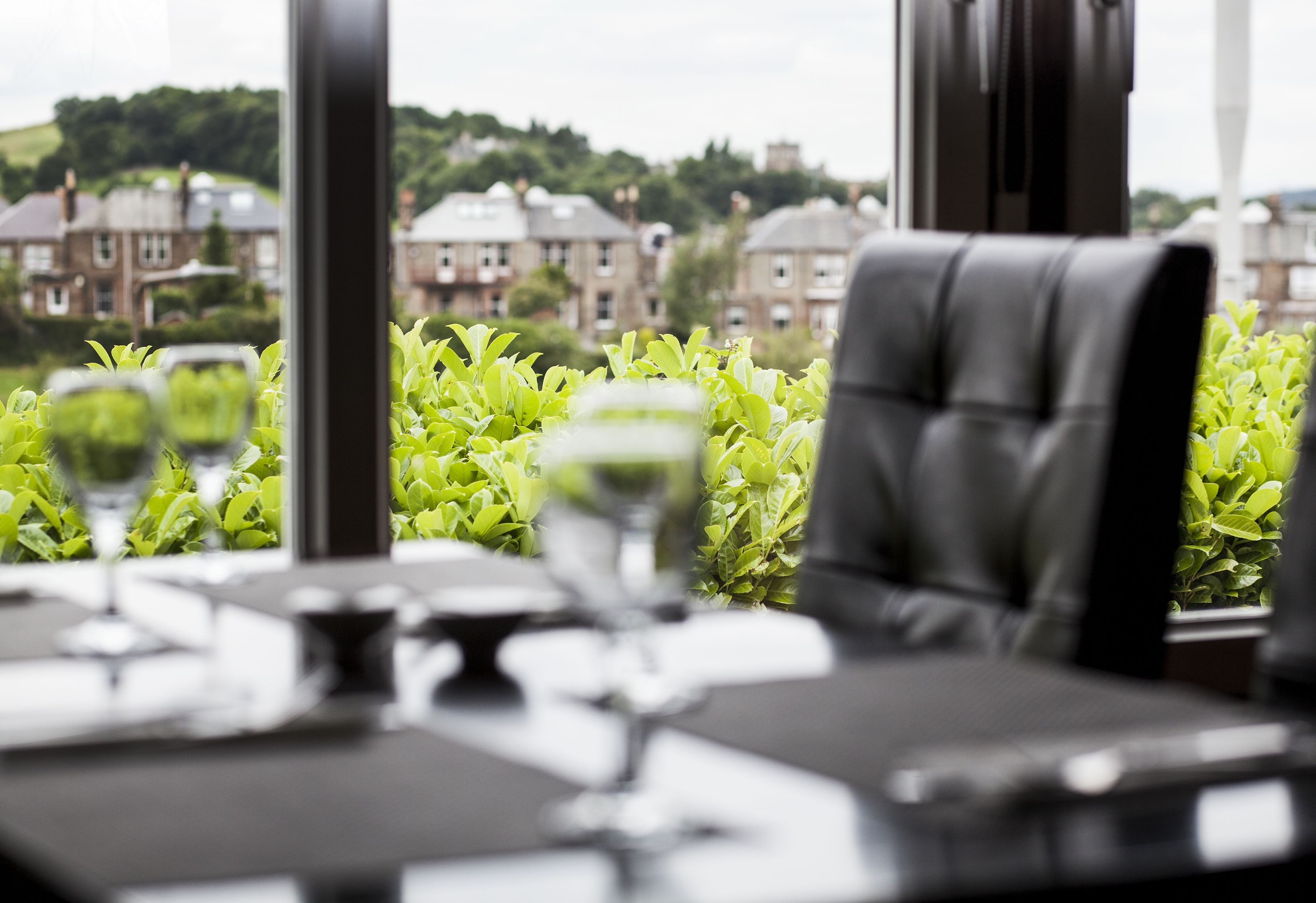 Una mesa de comedor con vistas a una zona residencial a través de amplios ventanales.