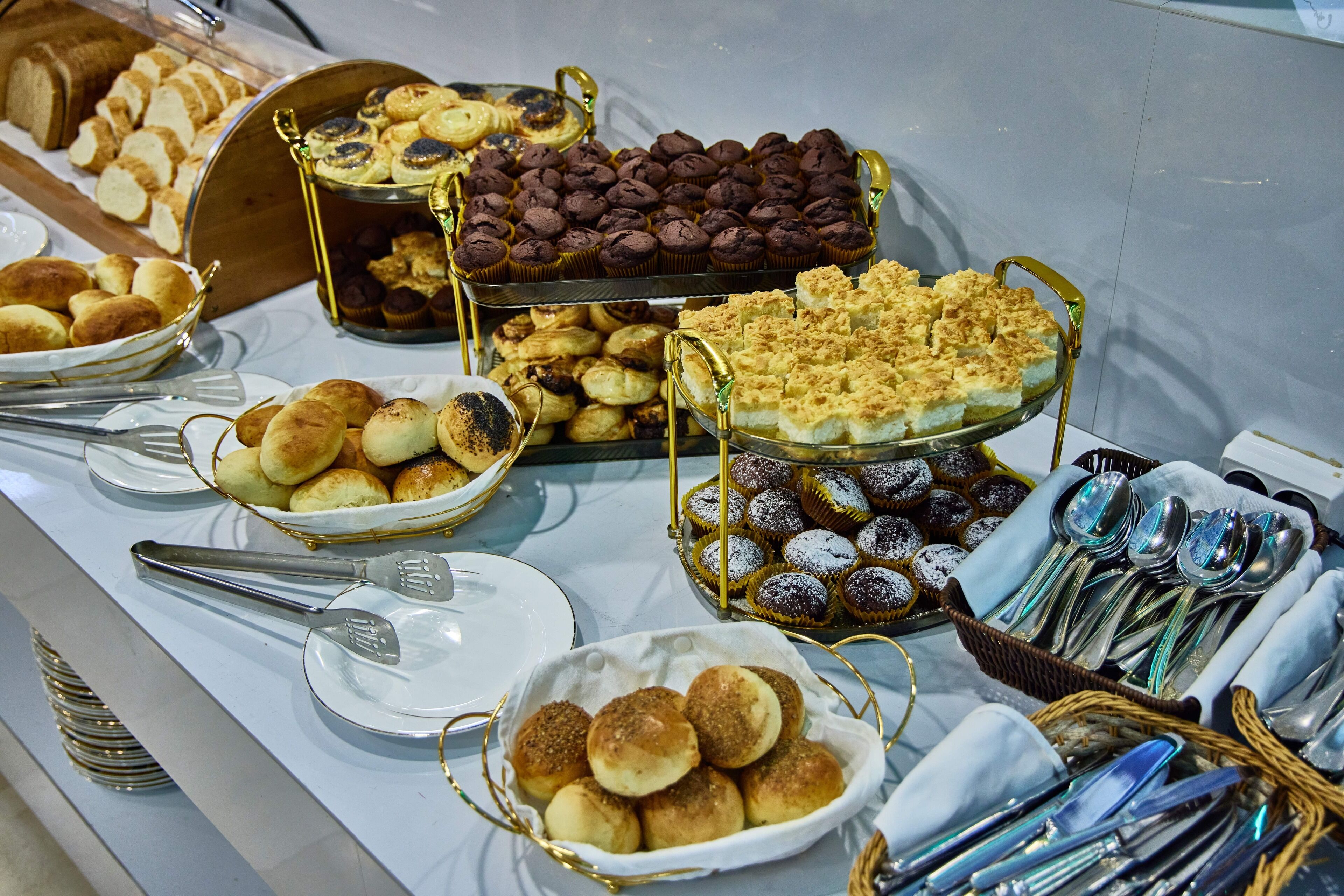 Un buffet proposant une variété de produits de boulangerie et d’ustensiles.