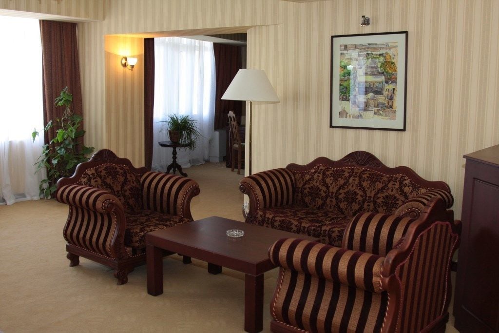 A living room with two striped sofas, a coffee table, a lamp, and a framed picture on the wall.