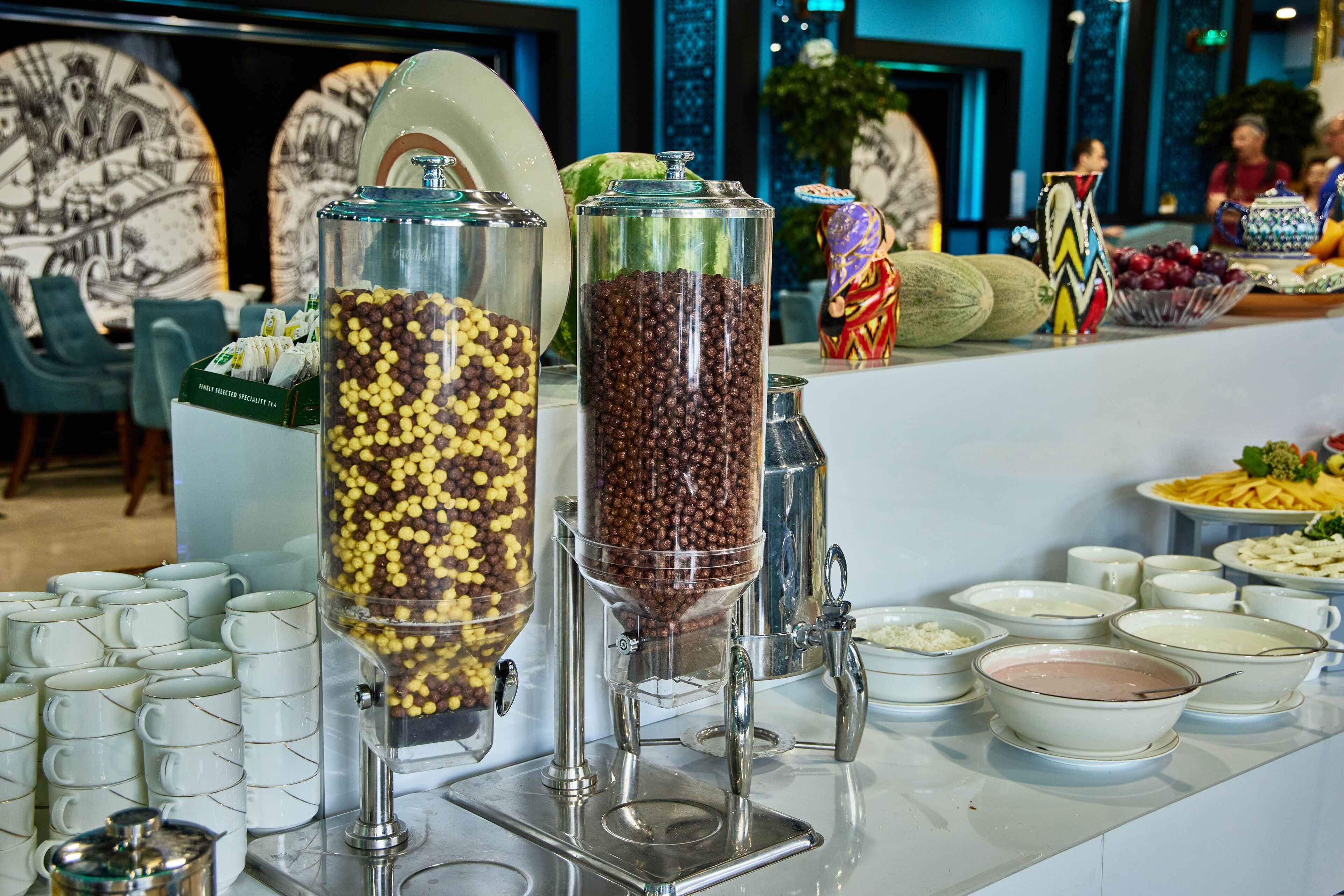 A buffet setup with various food containers and utensils.