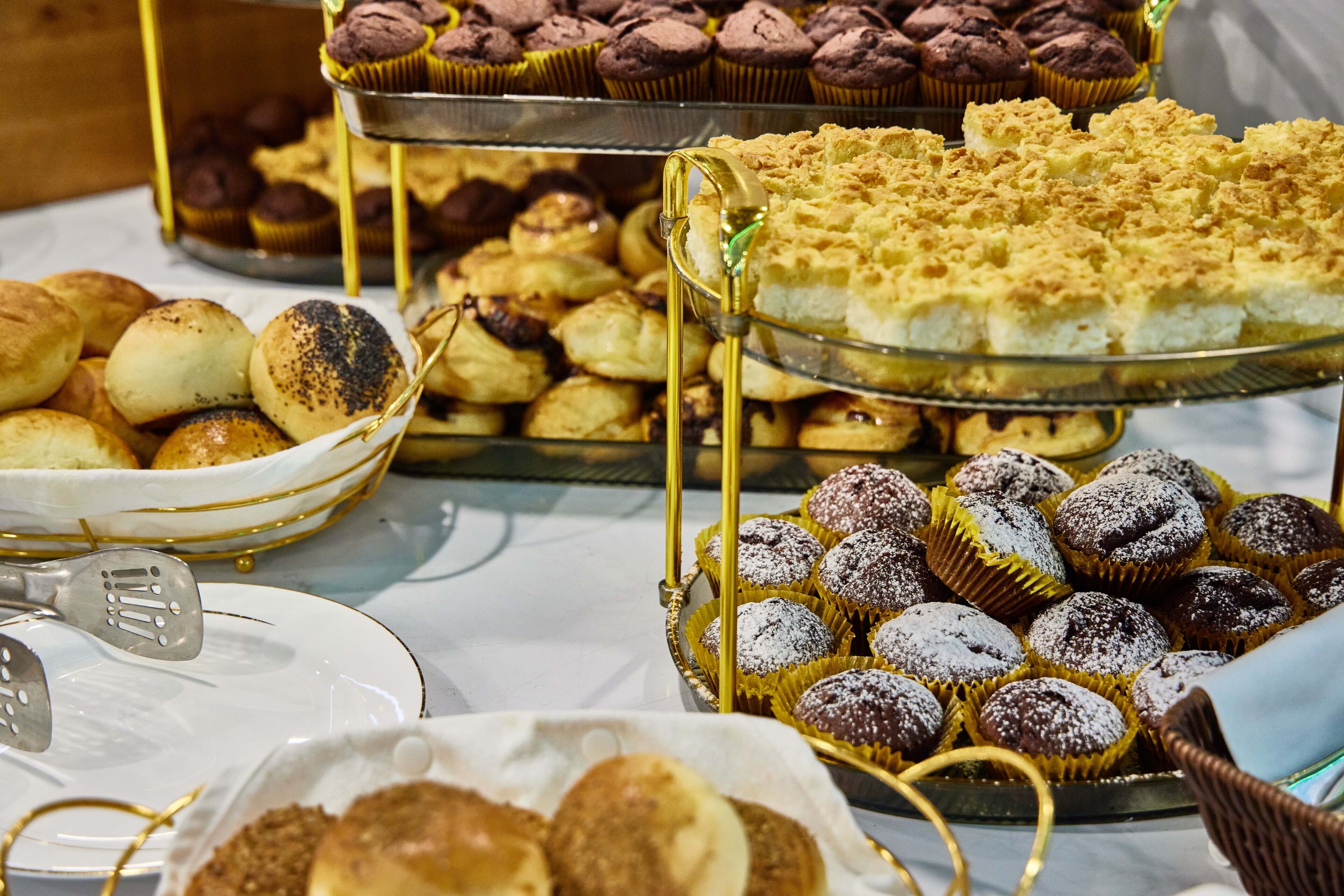 Un buffet proposant une variété de pâtisseries et de desserts, présentés sur plusieurs présentoirs.