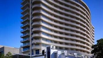 A multi-story hotel with a curved facade, large windows, and a prominent entrance.