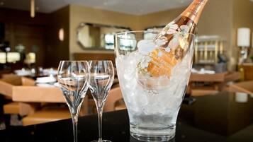 Une bouteille de champagne dans un verre rempli de glaçons, posée sur une table dans un restaurant.
