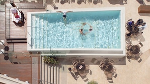 A rooftop pool with clear blue water, surrounded by lounge chairs and tables. - Rydges South Bank (South Brisbane)