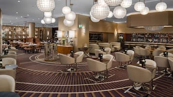 A hotel lobby with multiple seating areas, a bar, and a reception desk.