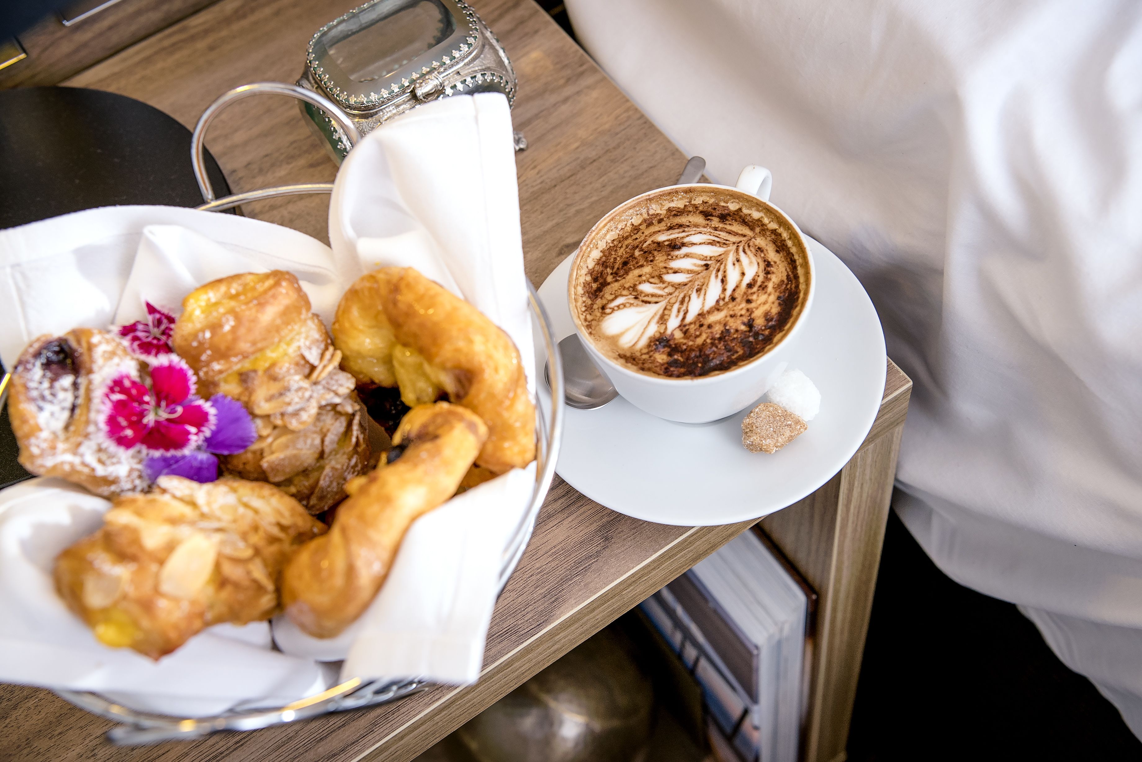 A tray with pastries and a cup of coffee on a wooden table.