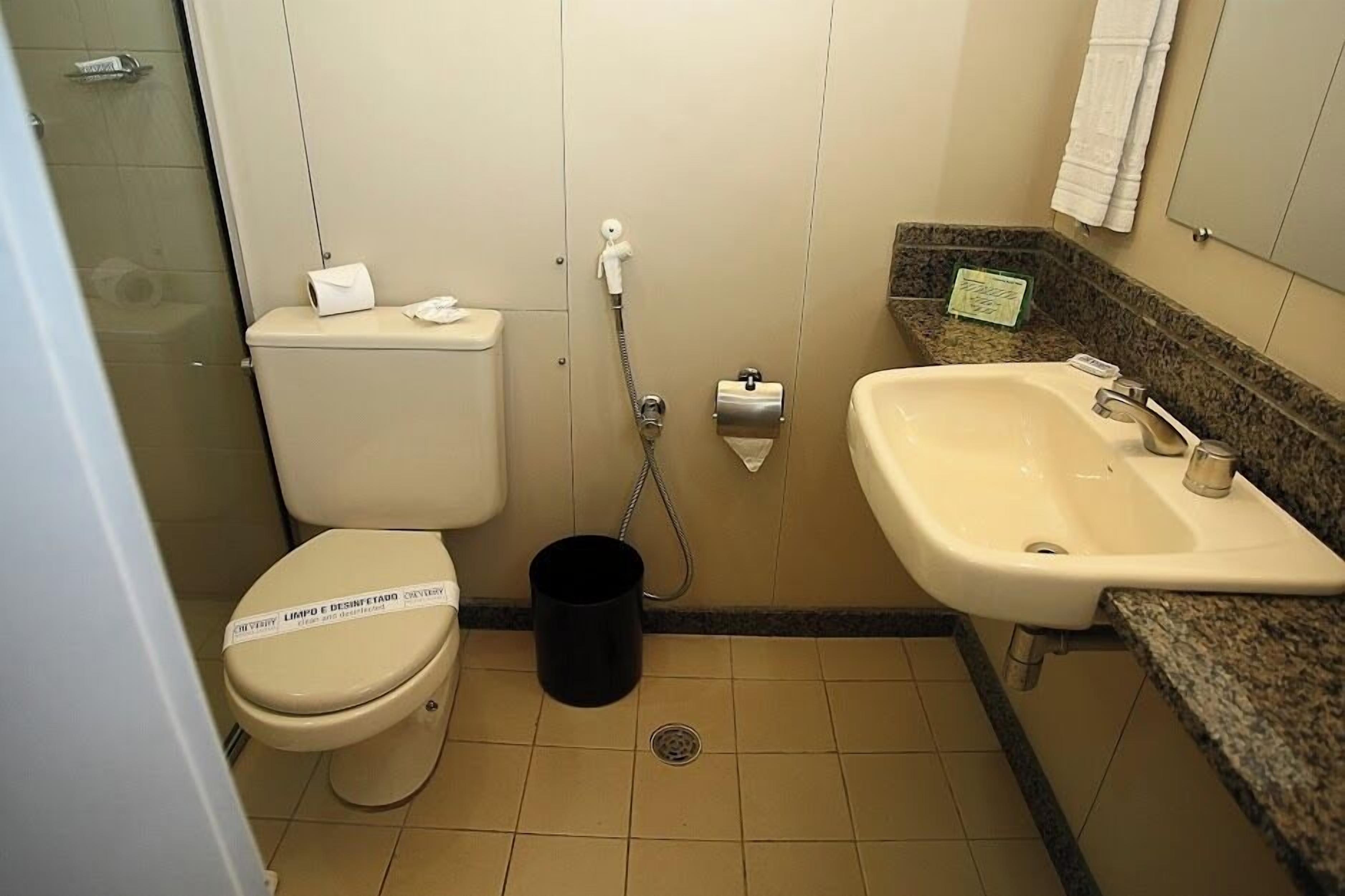 Un baño pequeño con inodoro, lavabo y ducha.