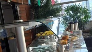 A buffet setup with various food items and beverages, including a hot air balloon decoration. - Cheverny Apart Hotel (Belo Horizonte)