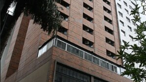 A tall, modern building with a brick facade and multiple windows. - Cheverny Apart Hotel (Belo Horizonte)