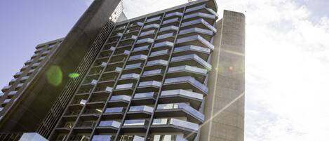 Um edifício alto com várias varandas e design arquitetônico moderno.