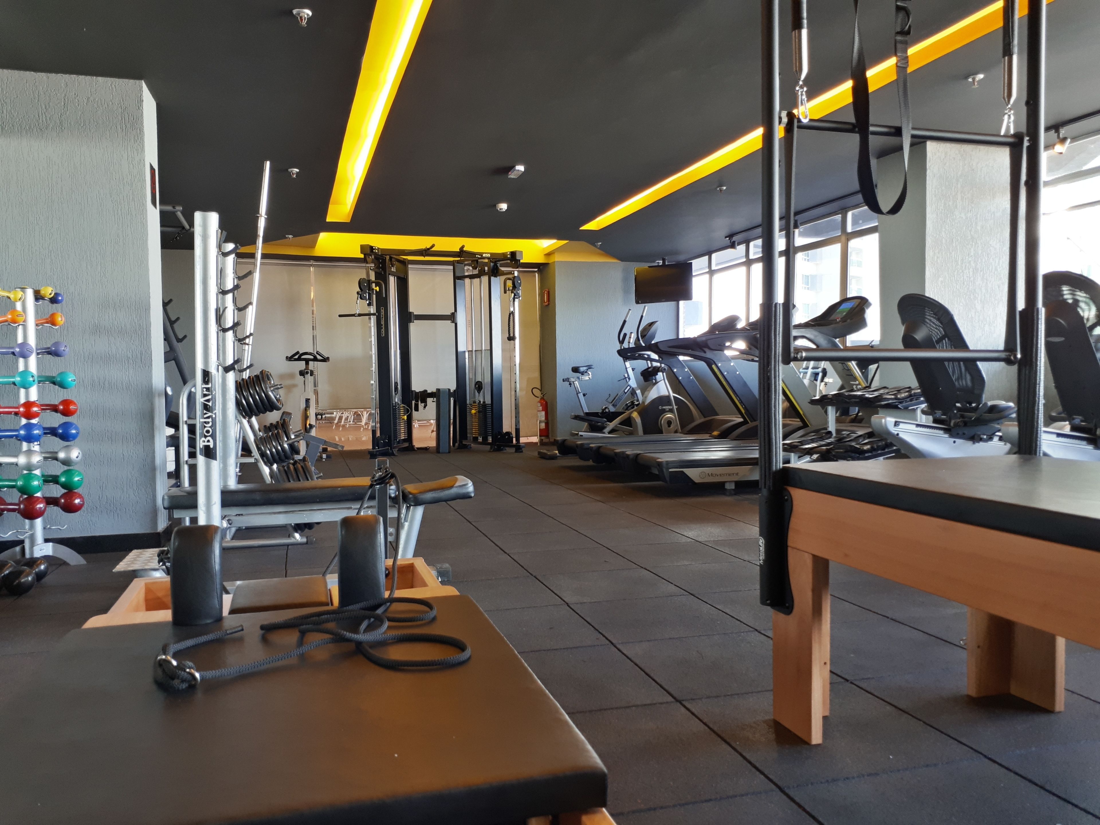 Une salle de sport équipée de divers appareils d’exercice, notamment des tapis de course et des appareils de musculation.