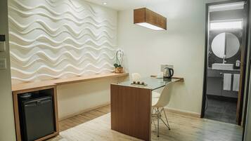 Una cucina moderna con piano di lavoro in legno, un tavolo in vetro e un frigorifero integrato.