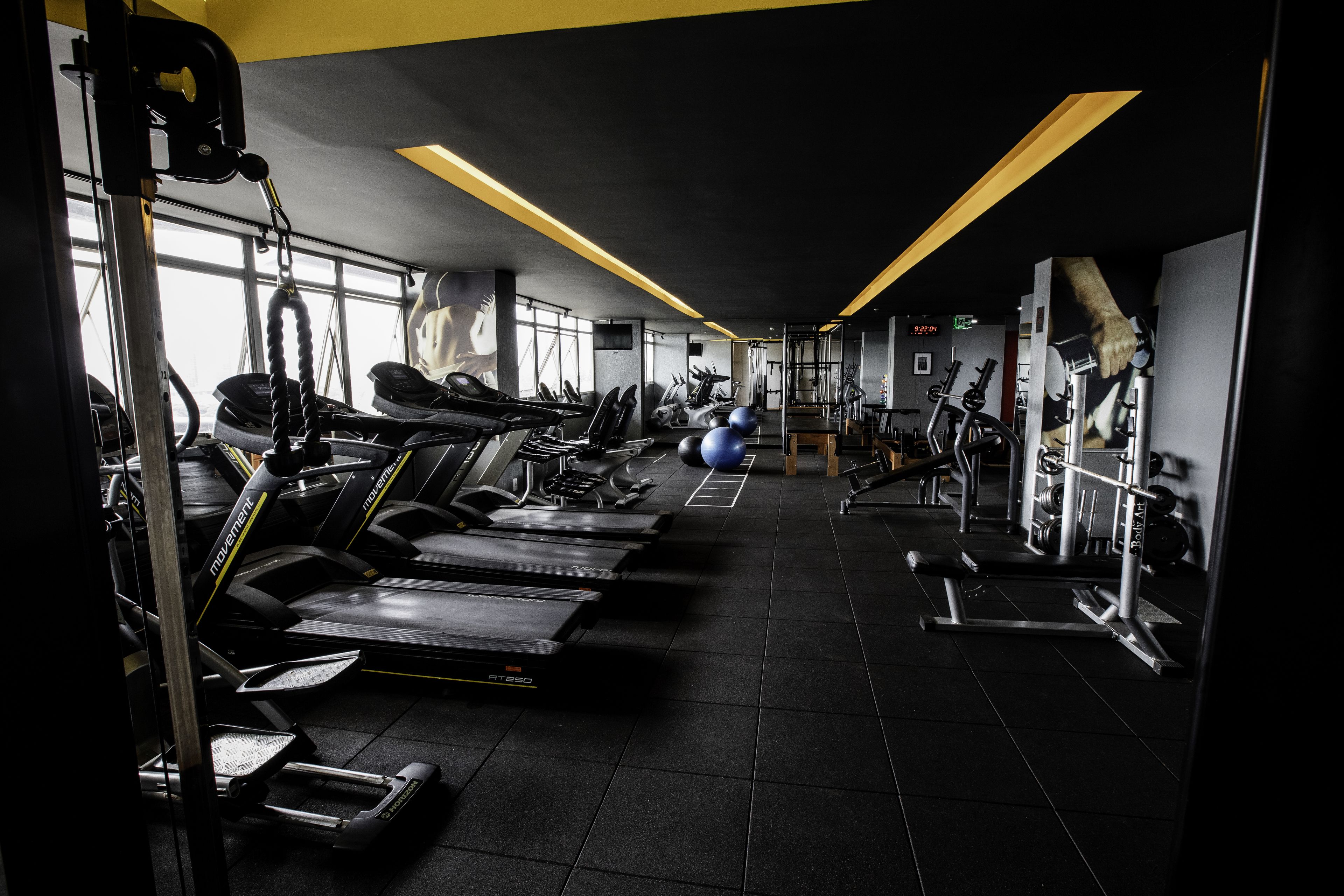 Une salle de sport équipée de tapis de course, de ballons d'exercice et d'appareils de musculation.
