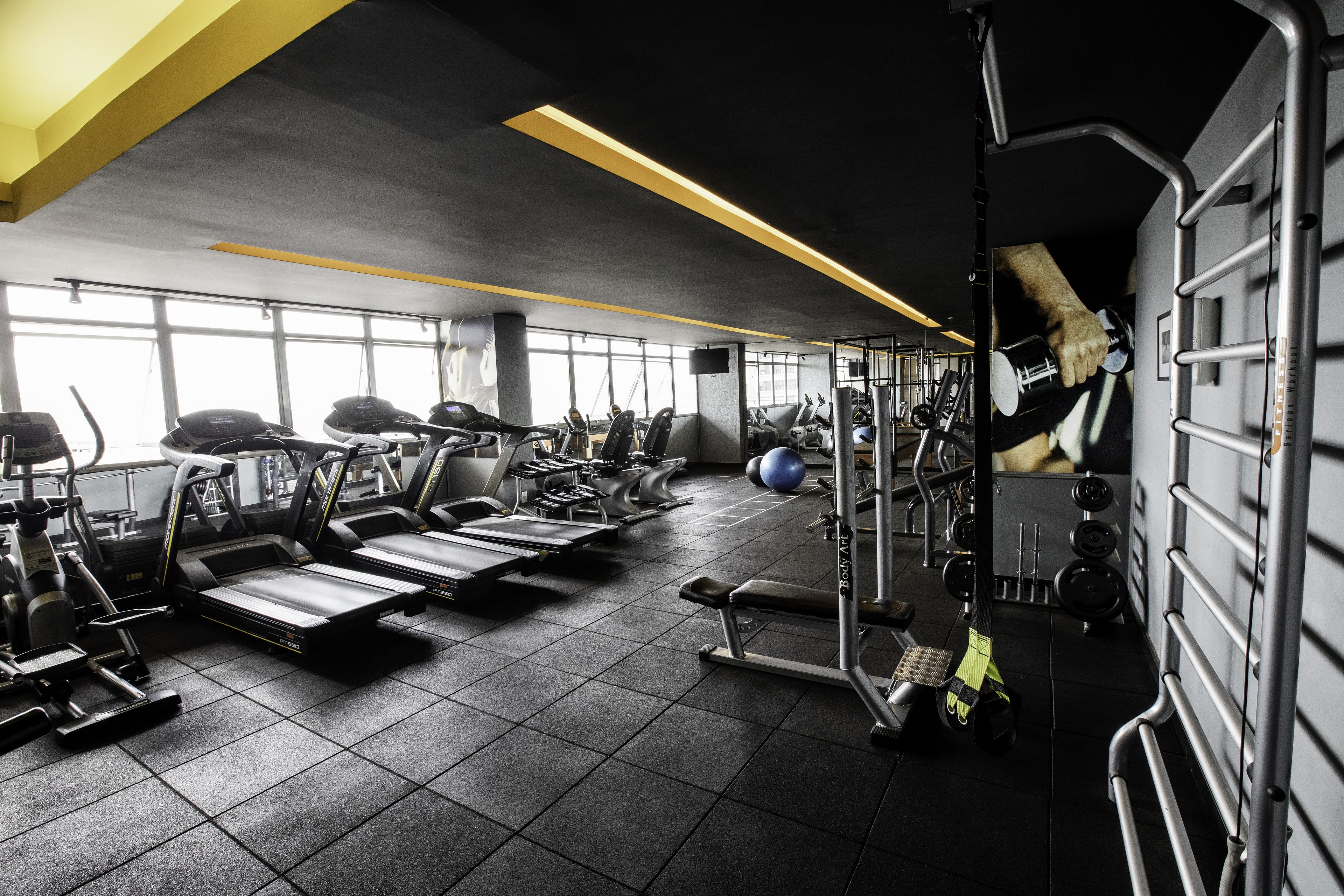 A gym with treadmills, weight machines, and exercise balls.