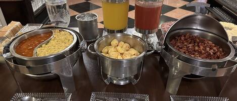 Una mesa de buffet con diversos alimentos y bebidas.