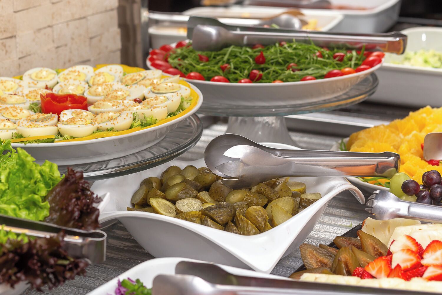 Ein Buffet mit verschiedenen Speisen, darunter Eier, Salate und Obst.