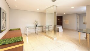 A spacious lobby with a reception desk, a glass partition, and a seating area. - Roochelle Hotel by Nobile (Curitiba)