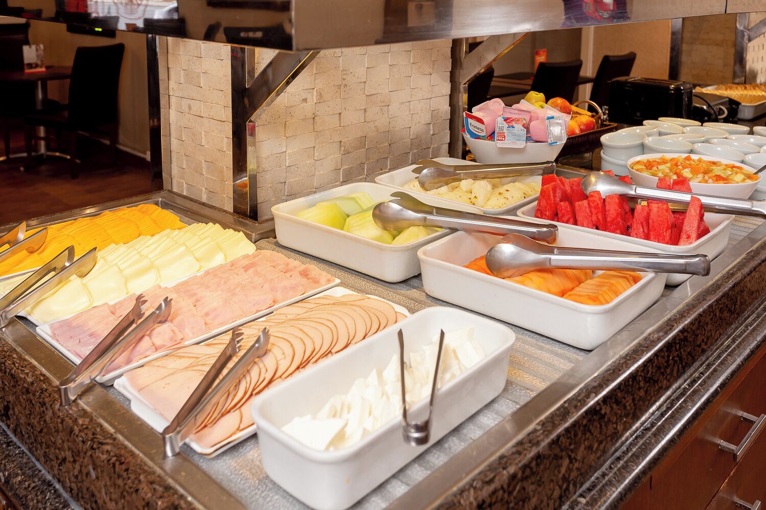 Buffet com diversos alimentos, incluindo frutas, legumes e carnes.