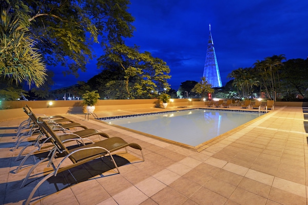 Una piscina al aire libre, sillones reclinables de piscina