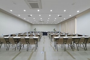A conference room with multiple tables and chairs, equipped with water bottles and nameplates. - Deville Prime Maringá (Maringá)