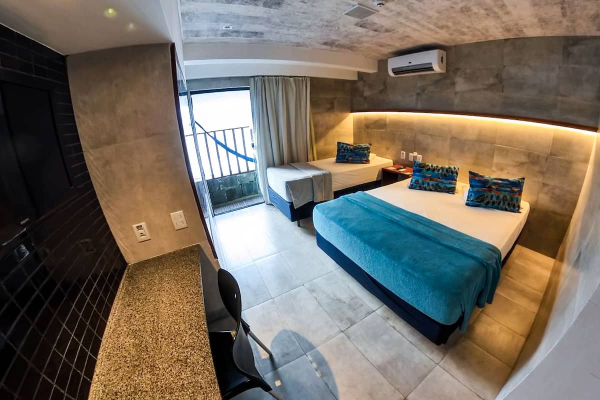 Una habitación de hotel moderna con una cama grande, un escritorio y un balcón.