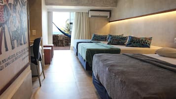 A hotel room with two beds, a desk, and a hammock.