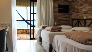 A hotel room with two beds, a view of the sea through a large window, and a hammock outside. - GoldMen Vila do Mar Natal (Natal)