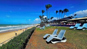 A beachside resort with a pool area, lounge chairs, and palm trees. - GoldMen Vila do Mar Natal (Natal)