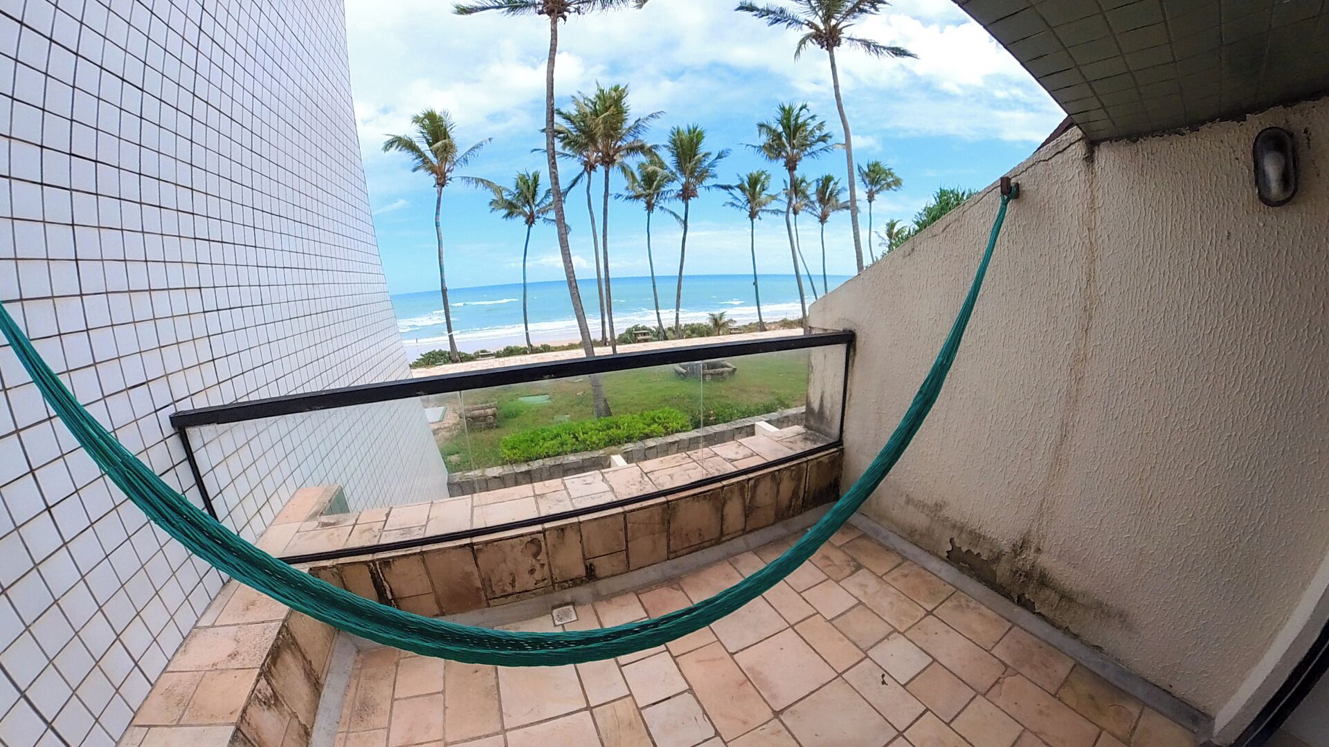 Un balcón con vista al océano y palmeras.