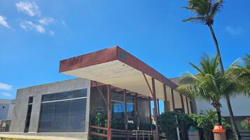 A modern building with a reception area, large windows, and a covered entrance.