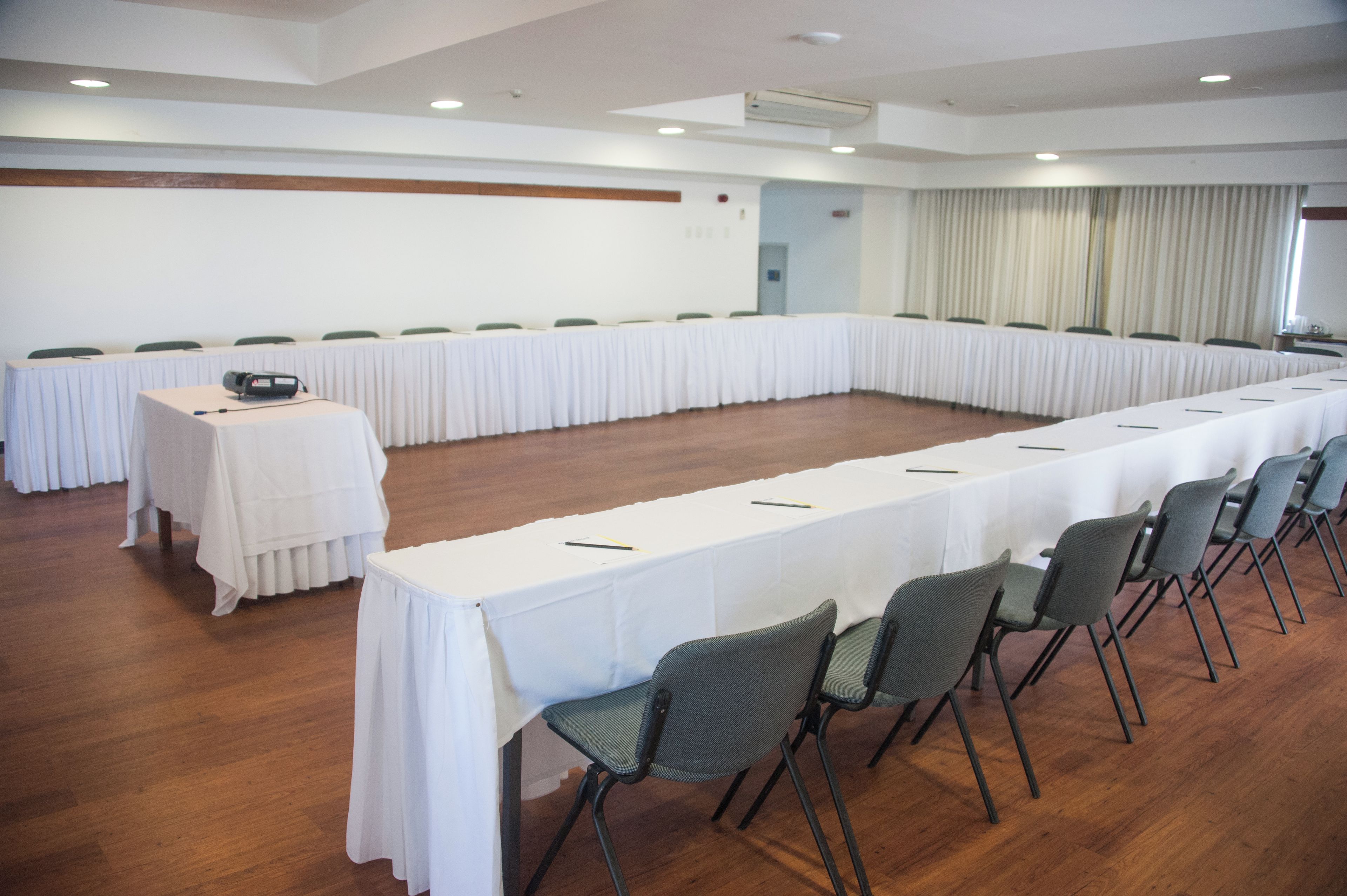 A conference room with a long table, chairs, and a projector.