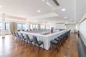 A conference room with a long table, chairs, and large windows.