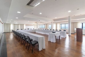 A large conference room with a long table, chairs, and a podium.