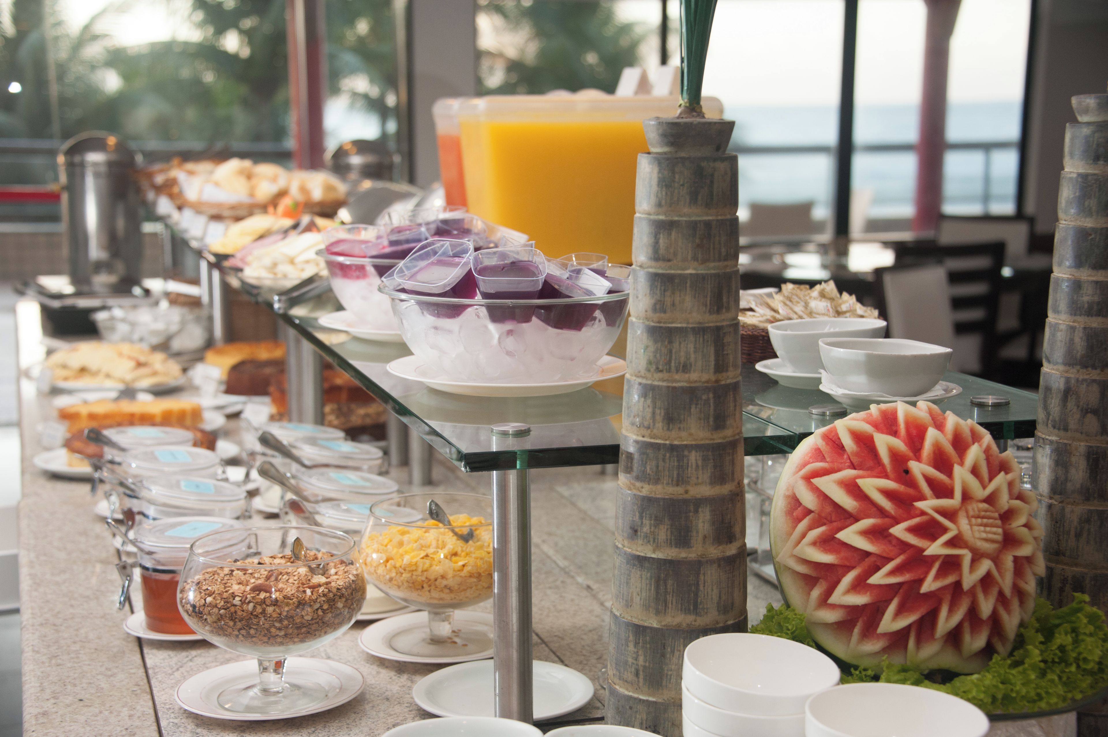 Una mesa de buffet con diversos alimentos y una decoración central de sandía.