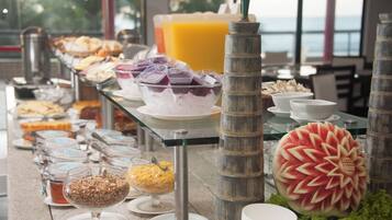Una mesa de buffet con diversos alimentos y una decoración central de sandía.