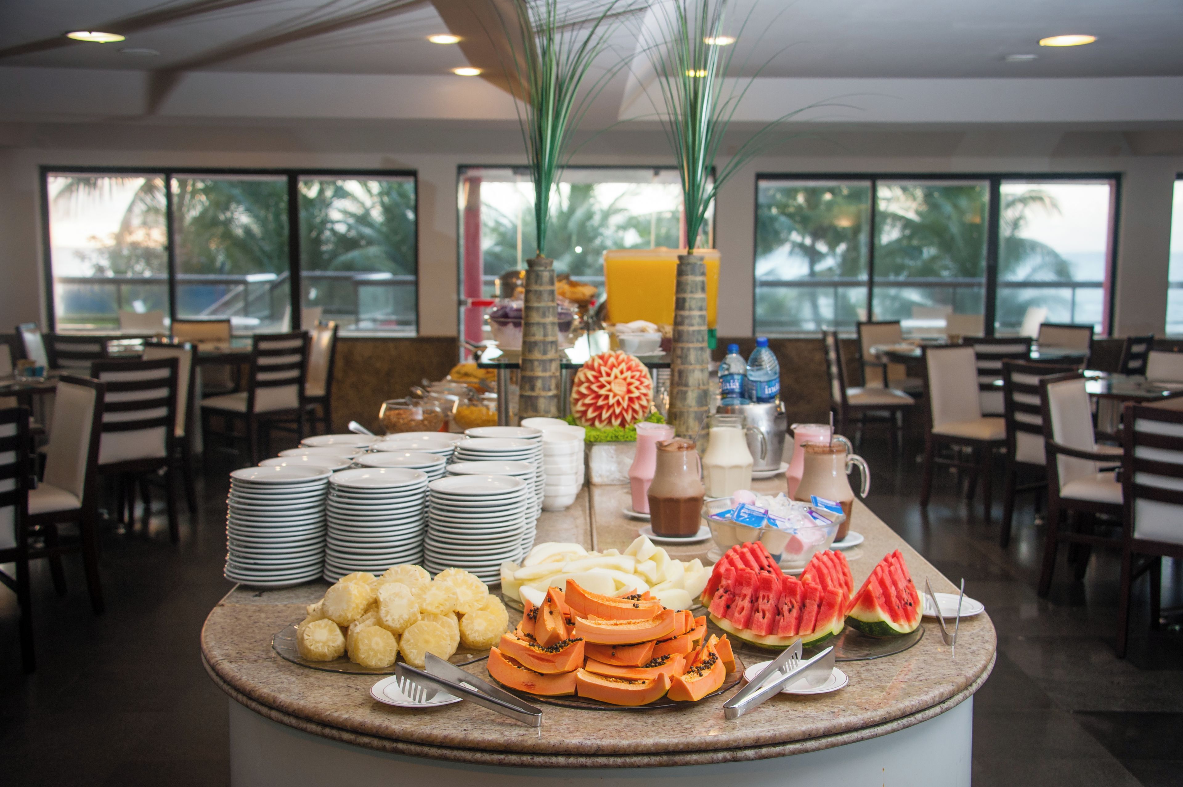 Montaje tipo bufé con frutas, bebidas y platos variados.