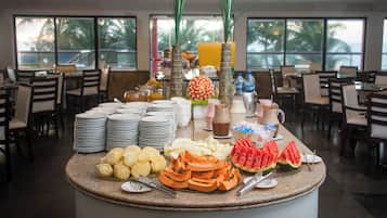 Montaje tipo bufé con frutas, bebidas y platos variados.