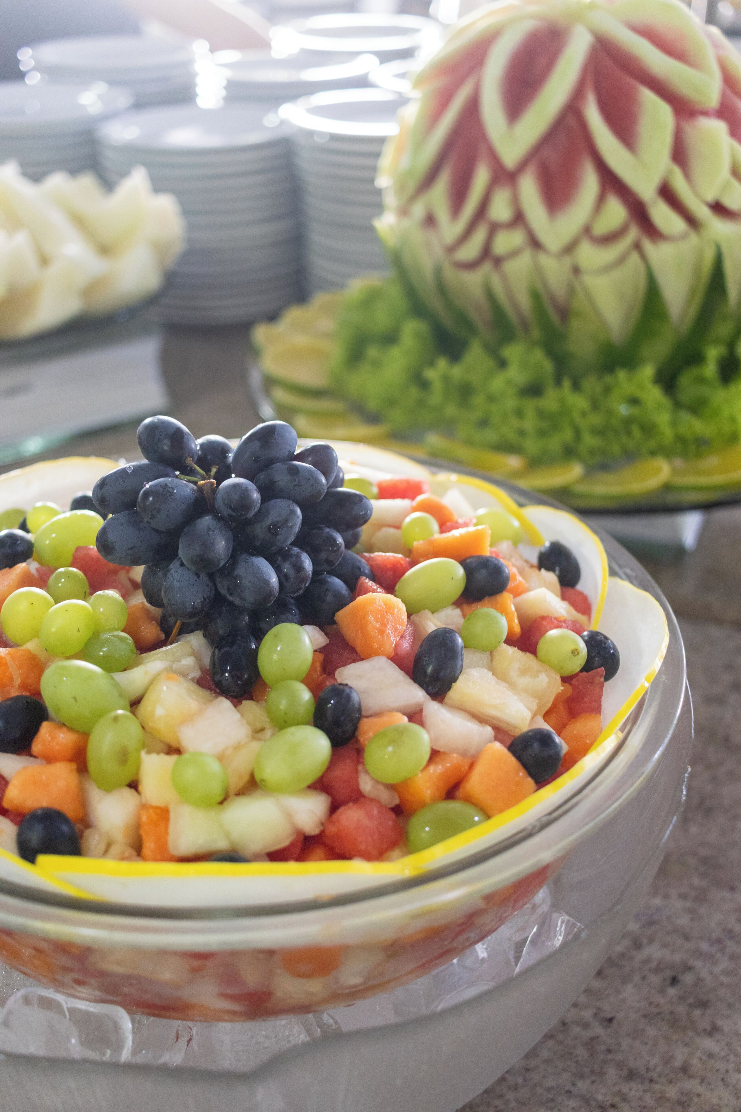 A fruit salad bowl with grapes, melon, and berries.
