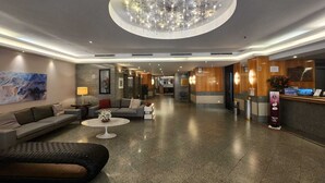 A spacious lobby with a modern chandelier, sofas, a coffee table, and a reception desk. - Mirador Rio Hotel (Rio de Janeiro)