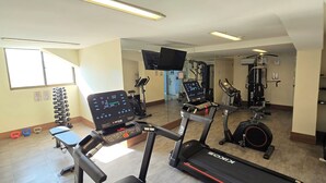 A gym with treadmills, weight machines, and a mirror wall. - Mirador Rio Hotel (Rio de Janeiro)