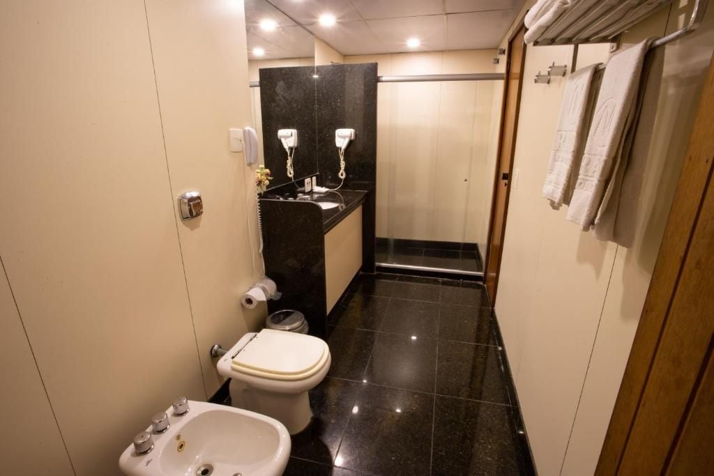 Un baño pequeño y funcional con inodoro, bidé y lavamanos.