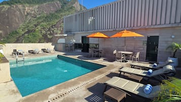Zona de piscina en la azotea con vista a un paisaje montañoso.