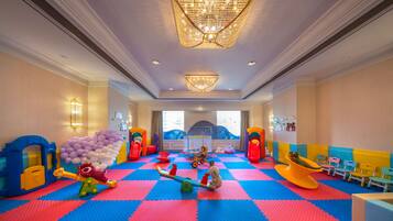 A children's play area with colorful play structures and a checkered floor.